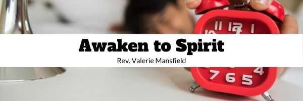 Red alarm clock with blurry figured in white bedclothes reaching to turn off alarm, Awaken to Spirit, Rev. Valerie Mansfield